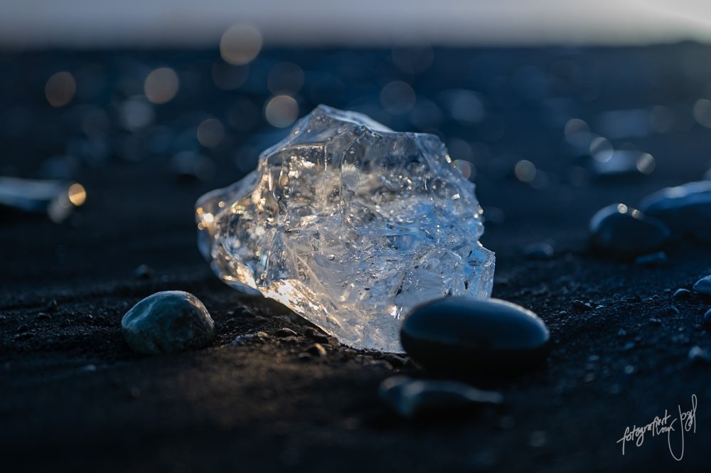 Eisstück auf schwarzem Sand