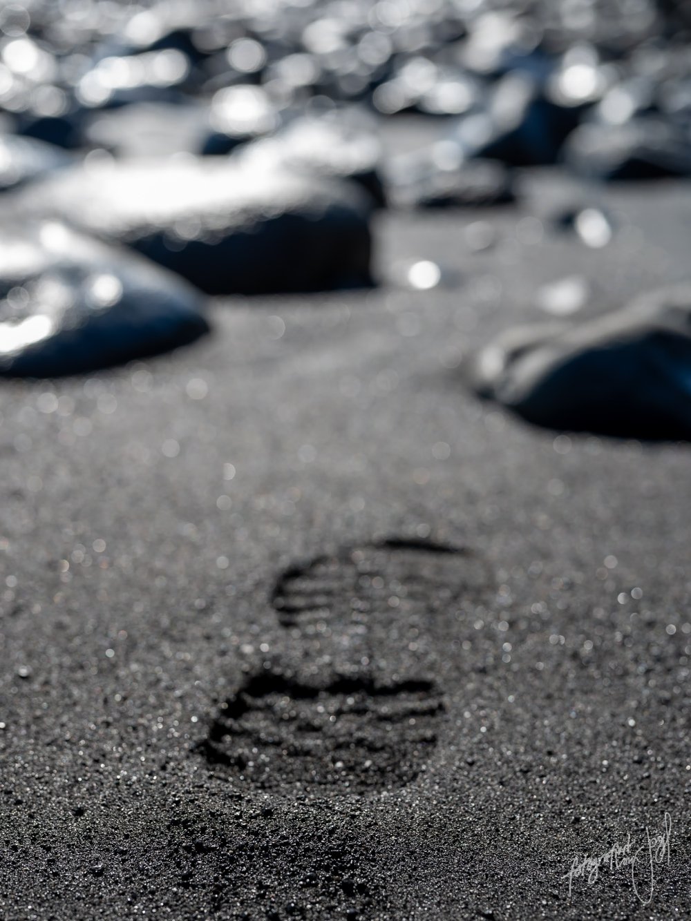 Fußabdruck im schwarzen Sand