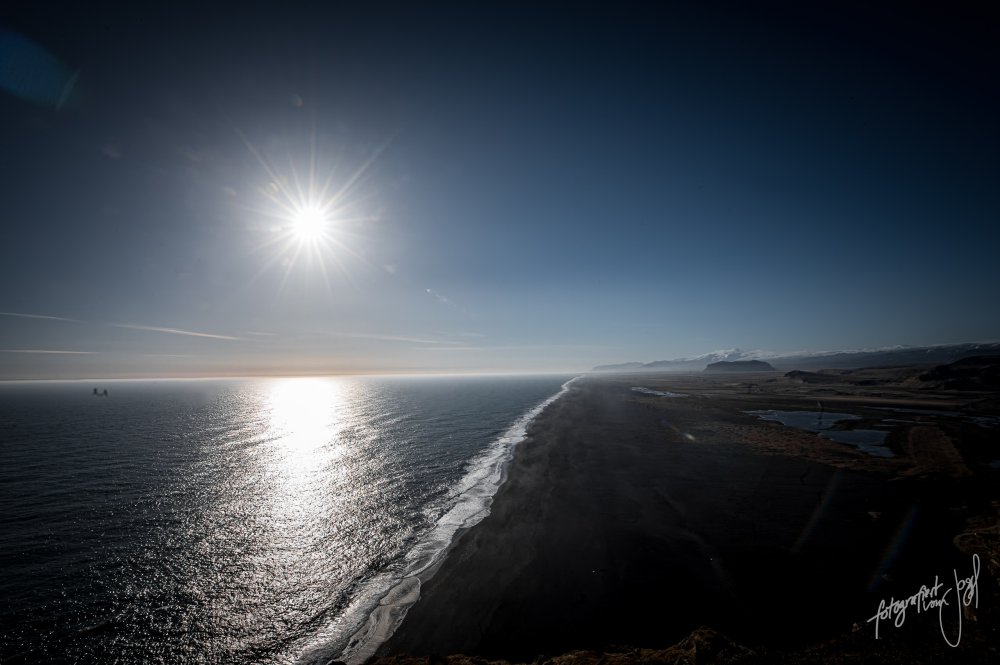 Sonne über dem schwarzen Strand